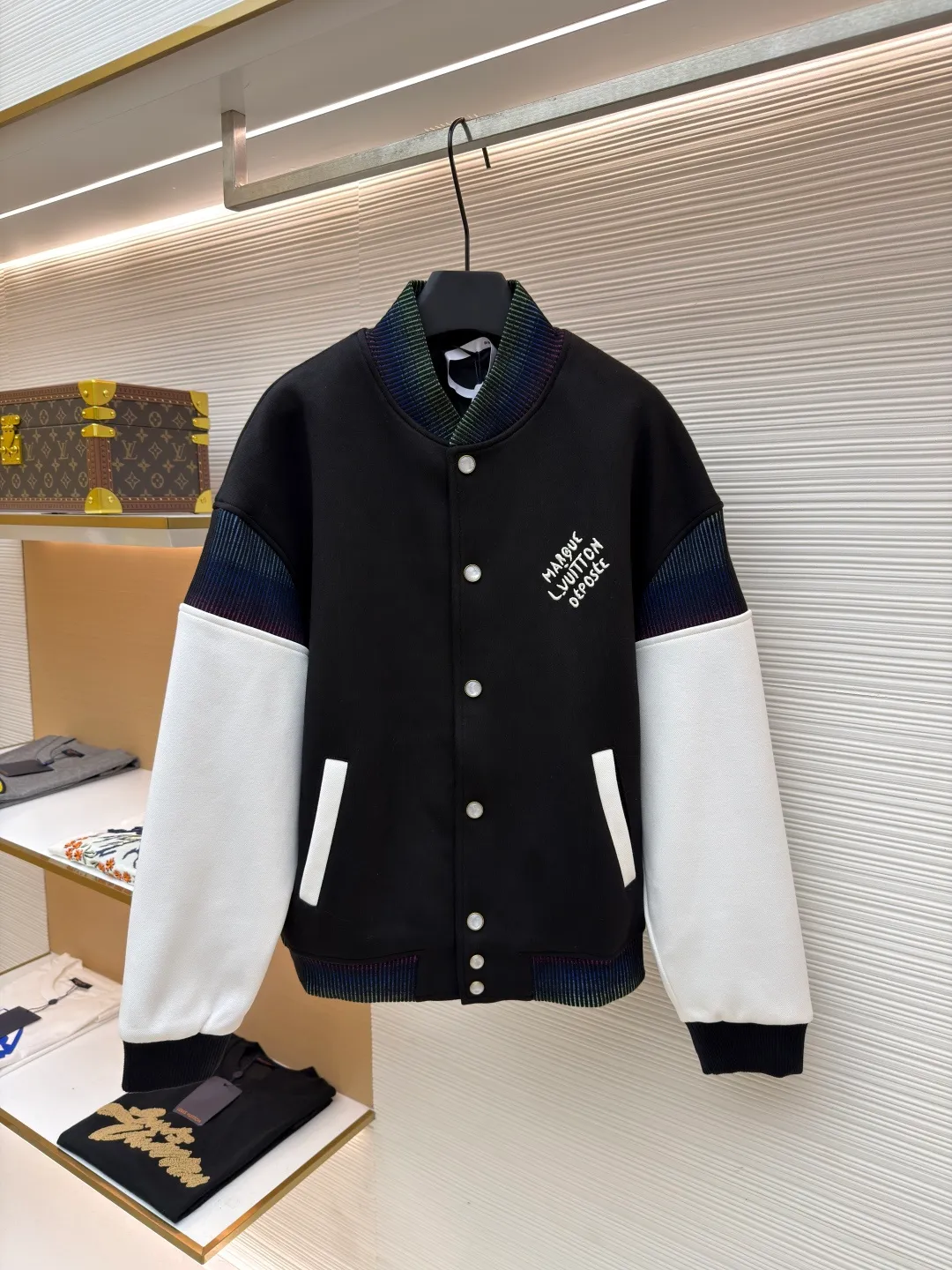 LOUIS VUITTON cotton knitted belted jacket baseball uniform ●Original version: 22000 purchased and developed ●Item number: 1681190-B90 ●Fabric: combed cotton double-strand pique fabric ●Technology: embroidery production ●Color: black and white ●Version: fitted version ●Weight: about 1190 ●Size: 46-48-50-52 ●Description: Made of wool blended fabric and leather splicing, the wool fabric is crisp and stylish, the leather part has a delicate texture, the splicing stitches are even, the transition is natural, and it highlights the exquisite clothing craftsmanship. - Embroidery technology: The embroidery stitches of the brand logo on the chest are fine, the pattern is clear, and it is highly integrated with the fabric, enhancing brand recognition. The pearl white resin buttons have a high-end texture, are harmonious with the overall style, and have strong durability; the ribbed collar, cuffs, and hem are made of high-elastic knitting technology, which has good elasticity, is comfortable to wear, and can effectively prevent wind. Classic baseball cut with a clean and stylish silhouette. Double thread reinforcement is used during sewing, the body is smooth and compliant, and the lines are straight, reflecting the brand's rigorous clothing making standards. The overall wiring is straight and delicate, the fabric is comfortable and soft, and the color is consistent without color difference. It can be matched with the same style to create a fashionable look and control various occasions. Customized accessories, complete with three standards, same style for men and women!